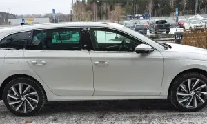 Vit Skoda Octavia laddhybrid parkerad i snö. Bilen har mörka fönster och snygga fälgar.