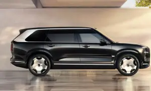 Svart Zeekr 9X SUV med silverdetaljer och unika fälgar, parkerad på ett glänsande golv.