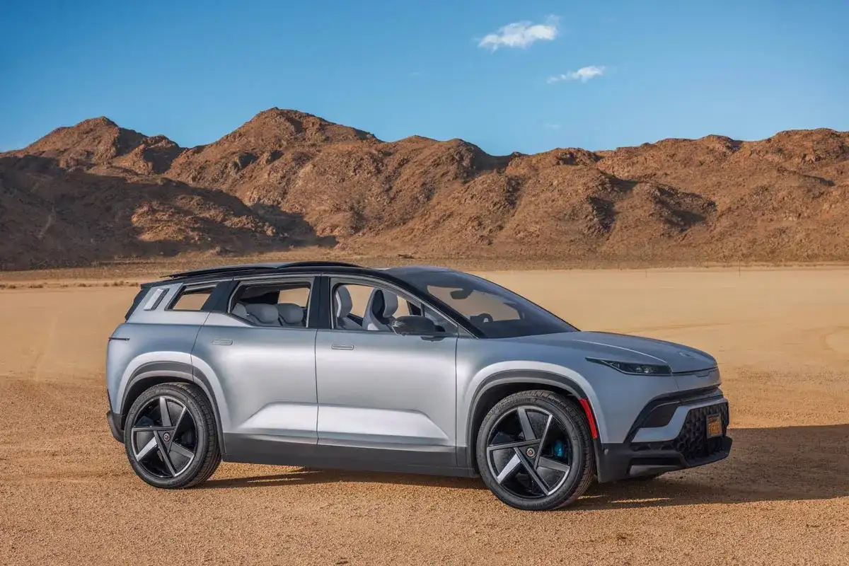 Silver Fisker Ocean SUV parkerad i en öken med berg i bakgrunden.