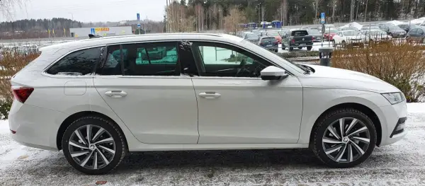 Vit Skoda Octavia laddhybrid parkerad i snö. Bilen har mörka fönster och snygga fälgar.