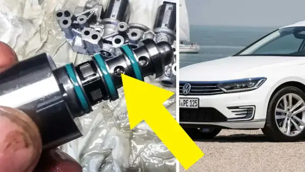 En mekaniker undersöker en del från en dubbeltrapp koppling, troligen relaterad till en vit Volkswagen vid havet.